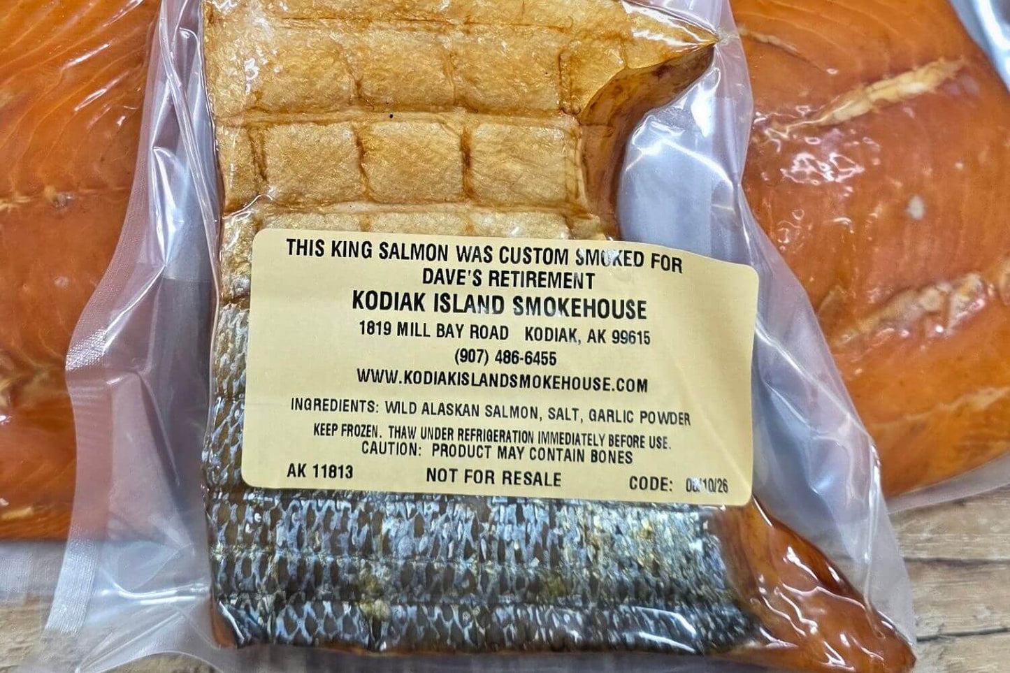 Close-up of a personalized label on custom-smoked Alaska king salmon, showing an example retirement message.