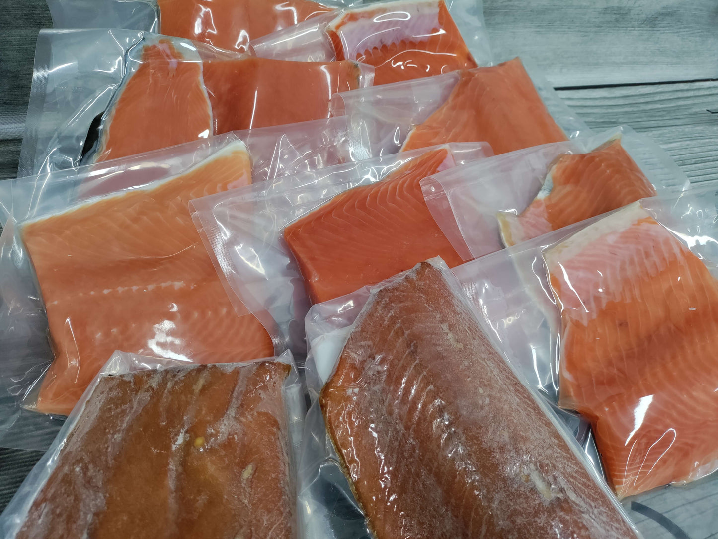Assorted packaged Wild Alaskan coho salmon portions including both raw and smoked pieces from a Kodiak Island Smokehouse Gone Fishing gift box