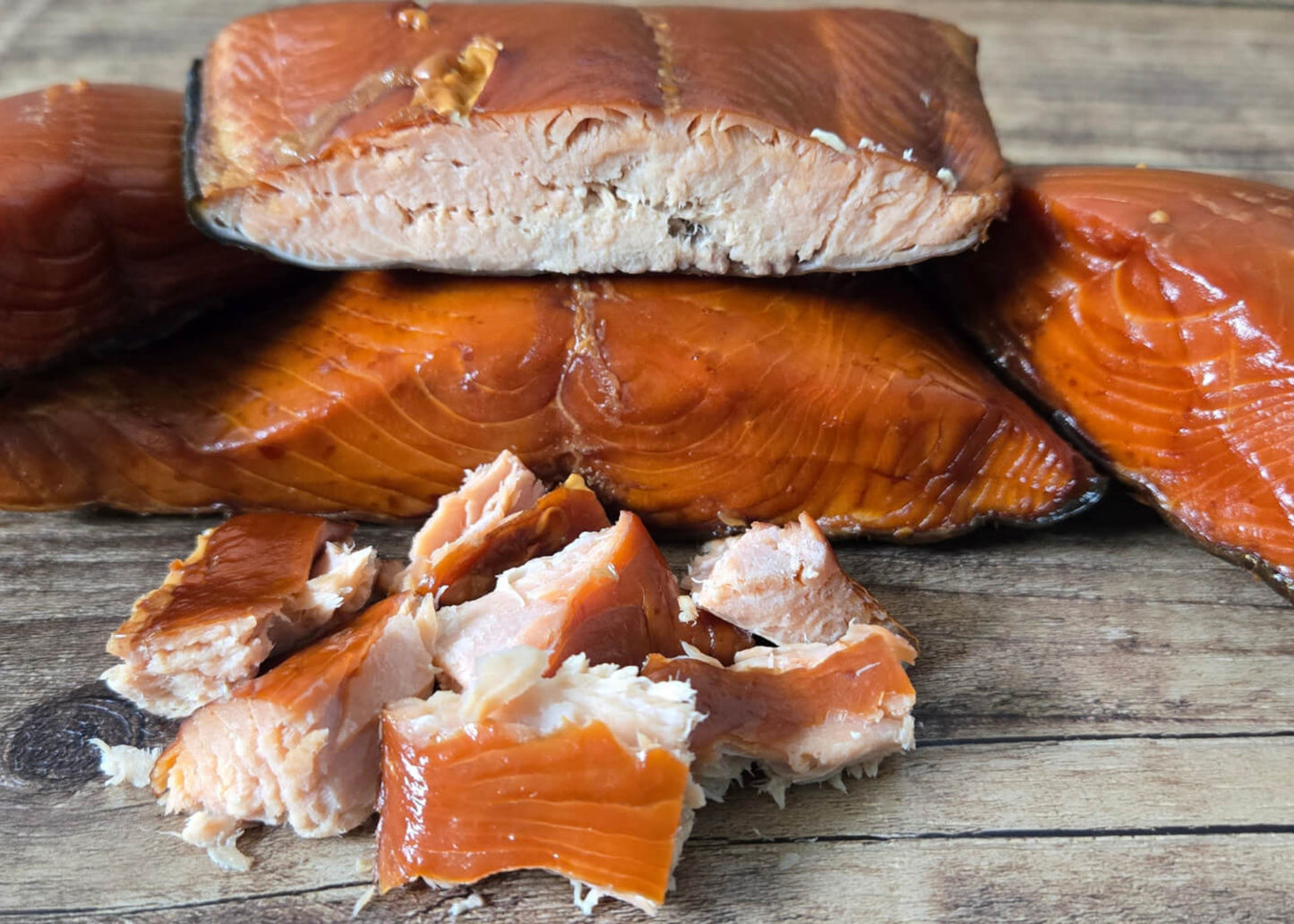 Smoked wild Alaskan king salmon fillets and pieces on a wooden board.