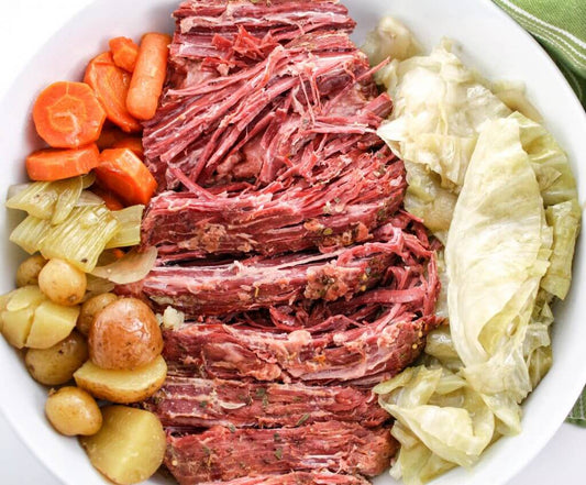 Close-up of tender corned game roast with red potatoes, carrots, and cabbage — a hearty Alaskan slow-cooked dinner from Kodiak Island Smokehouse.