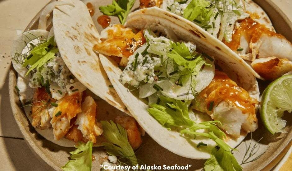 Soft flour tortillas filled with wild Alaska cod or lingcod tossed in buffalo sauce, topped with celery and fennel slaw, and drizzled with blue cheese ranch dressing, served with lime wedges.
