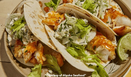 Soft flour tortillas filled with wild Alaska cod or lingcod tossed in buffalo sauce, topped with celery and fennel slaw, and drizzled with blue cheese ranch dressing, served with lime wedges.