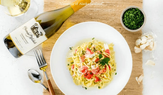 Bowl of linguine tossed with Alaska king crab, garlic, white wine, and crème fraîche sauce, garnished with parsley and served in a light butter sauce.