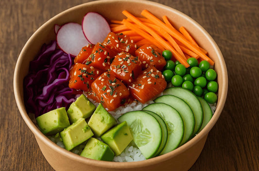 Kodiak poke bowl with sockeye salmon cubes, avocado, cucumber, purple cabbage, carrots, radish, and peas over rice.