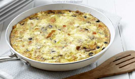 Alaska salmon pesto frittata with goat cheese, red peppers, and mushrooms in a skillet