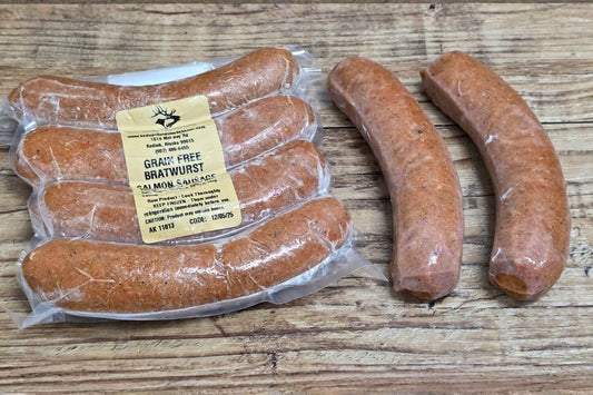 Wild Alaskan grain-free salmon bratwurst on rustic wood background, shown both vacuum-sealed and loose for a clear view of size and texture.