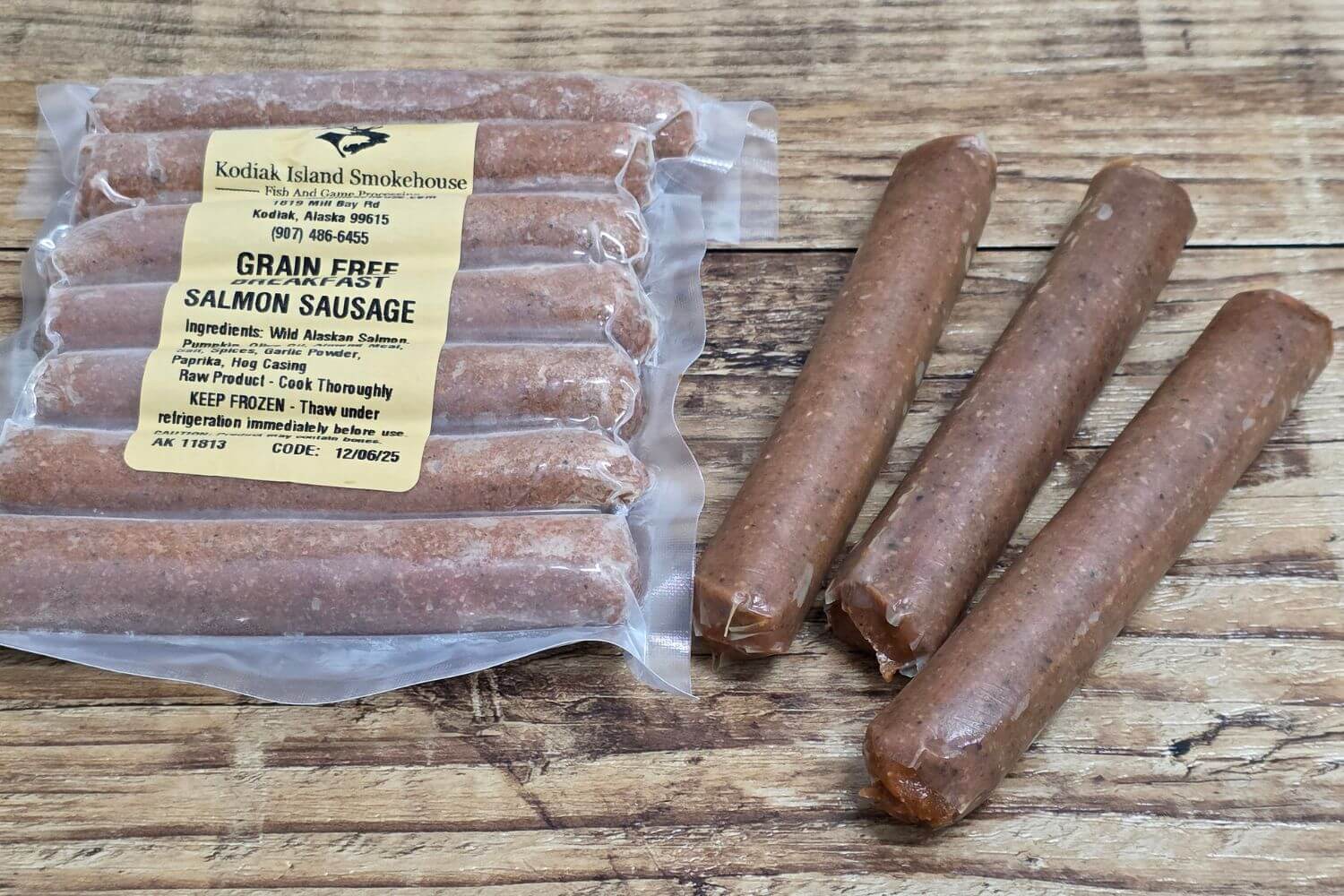 Grain-free Wild Alaskan salmon breakfast sausage, shown packaged and as loose links on a rustic wood surface.