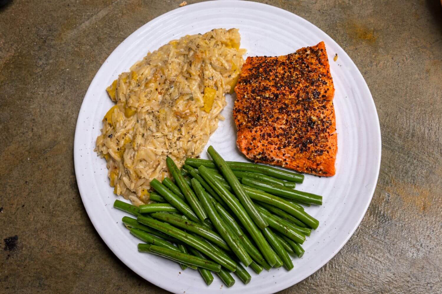 Baked salmon coated with Coldwater Crust seasoning served with green beans and orzo