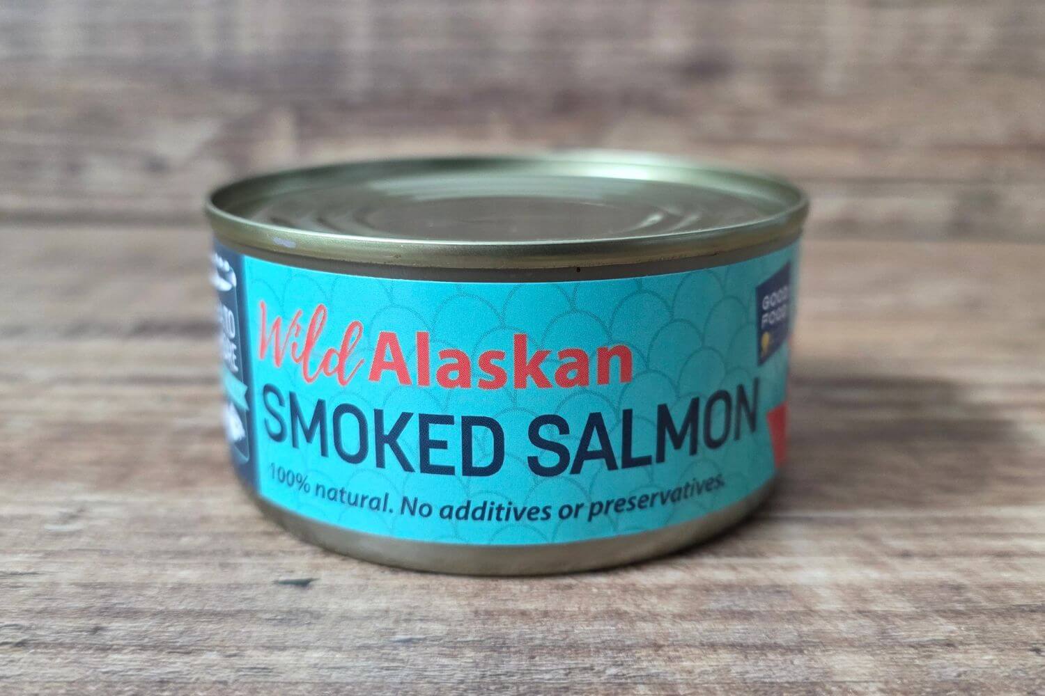 Wild Alaskan smoked pink salmon in a shelf-stable can on a wood background.