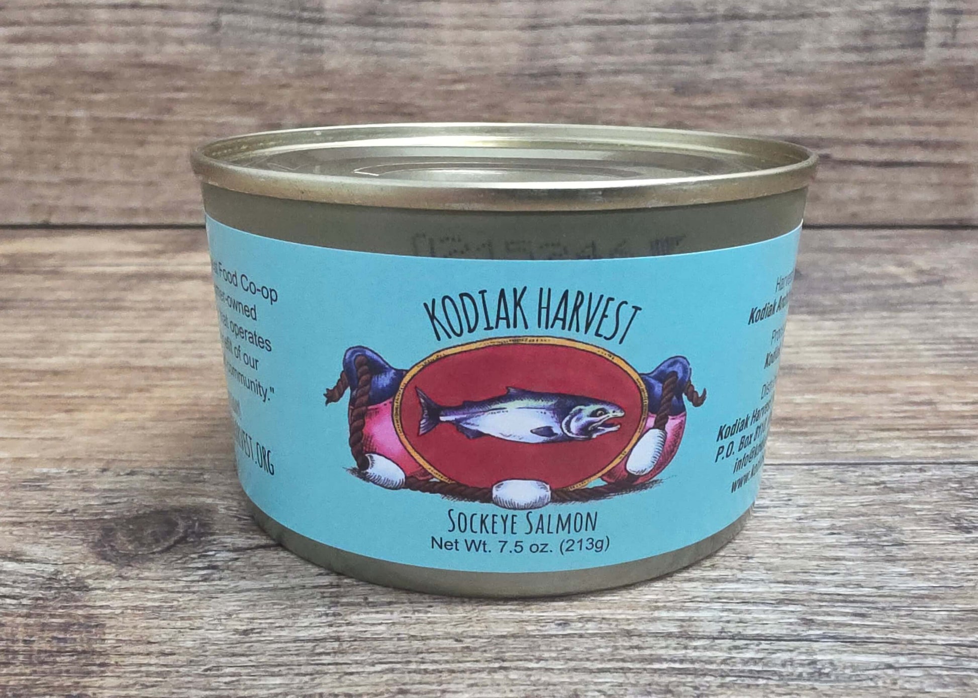 Canned sockye salmon with a blue label featuring a fish design on a wooden surface