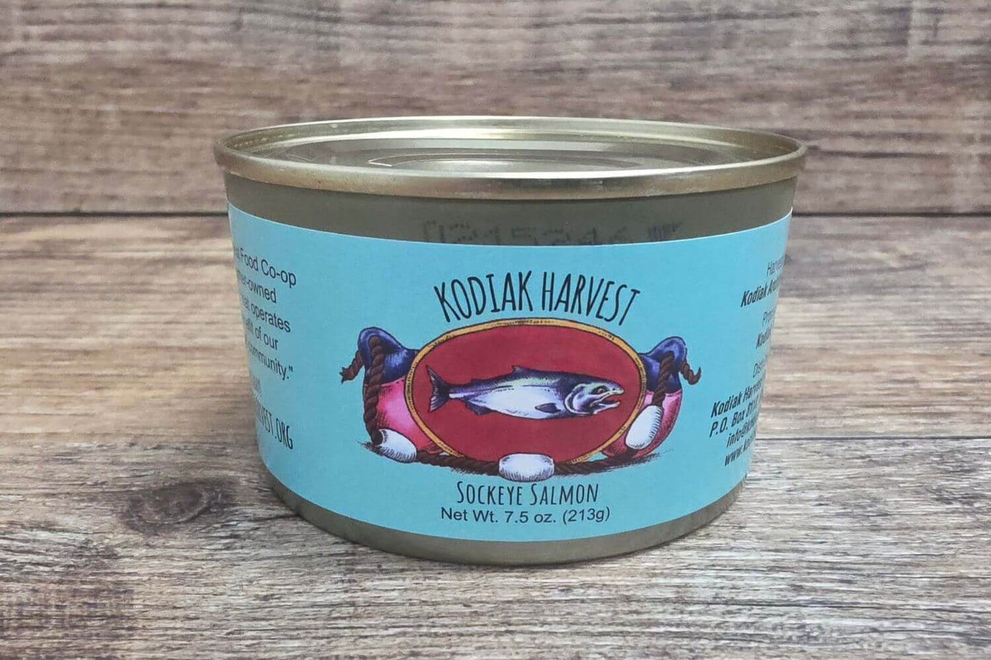 Canned sockye salmon with a blue label featuring a fish design on a wooden surface