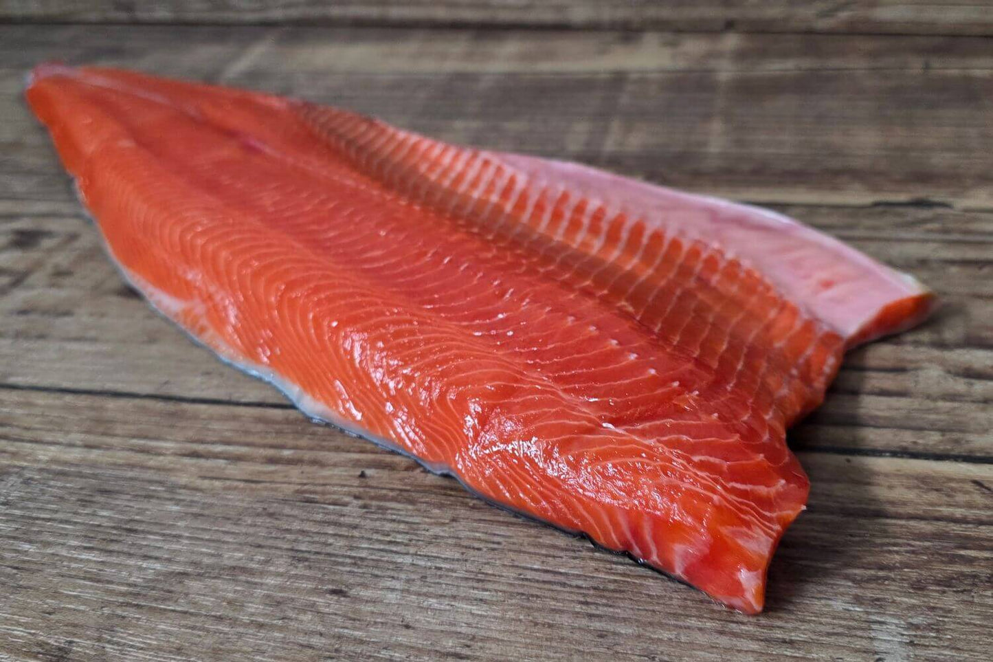 Raw Copper River sockeye salmon fillet on a wooden surface