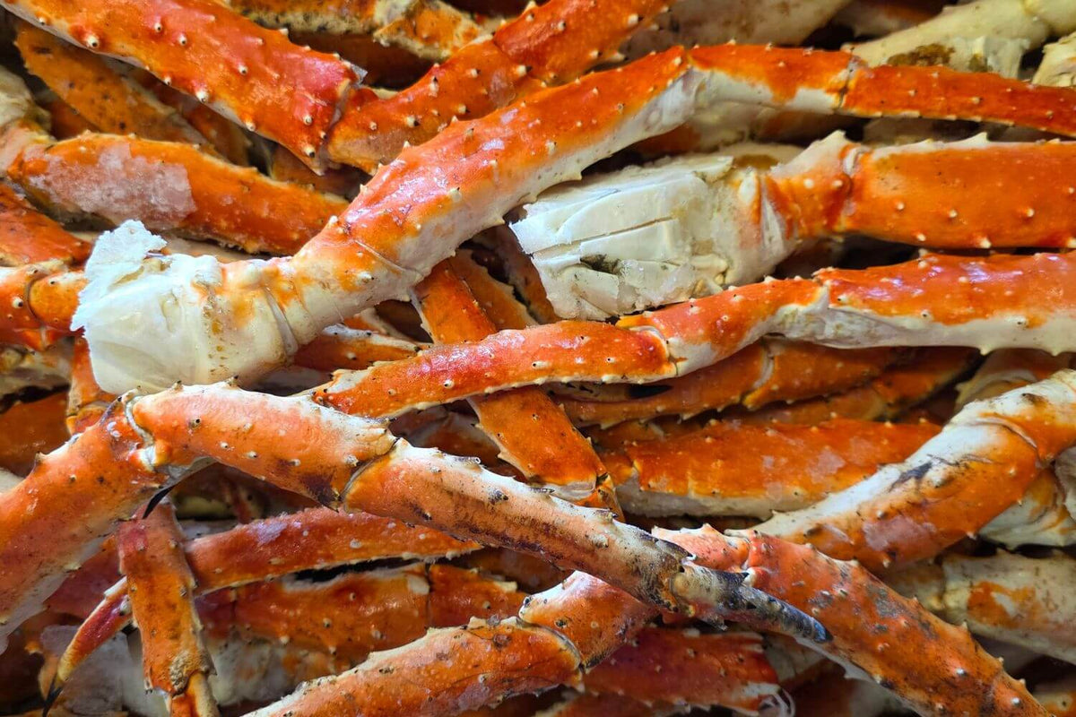 Close-up of frozen Wild Alaskan red king crab legs and claws showing natural shell color and texture