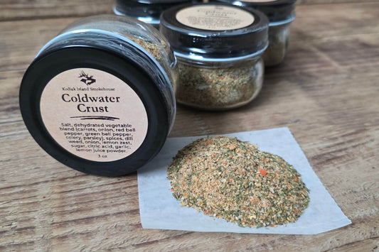Jar of Kodiak Island Smokehouse Coldwater Crust seasoning blend with loose seasoning displayed on parchment paper