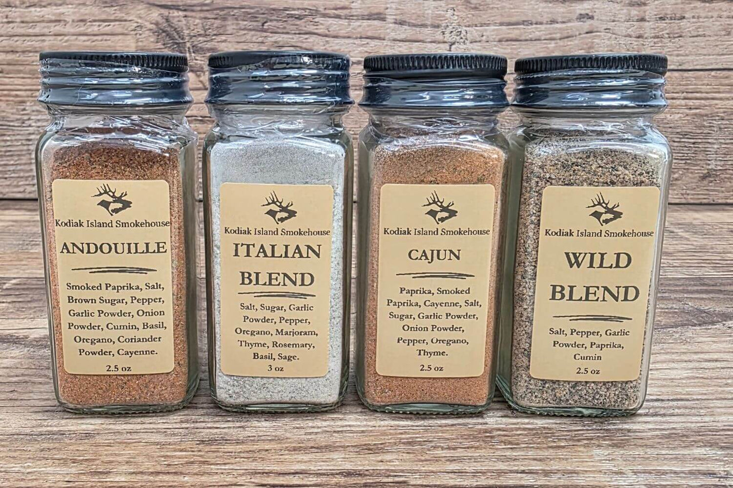 Four Kodiak Island Smokehouse seasoning blends including Andouille, Italian Blend, Cajun, and Wild Blend in glass jars
