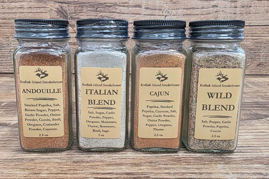 Four Kodiak Island Smokehouse seasoning blends including Andouille, Italian Blend, Cajun, and Wild Blend in glass jars