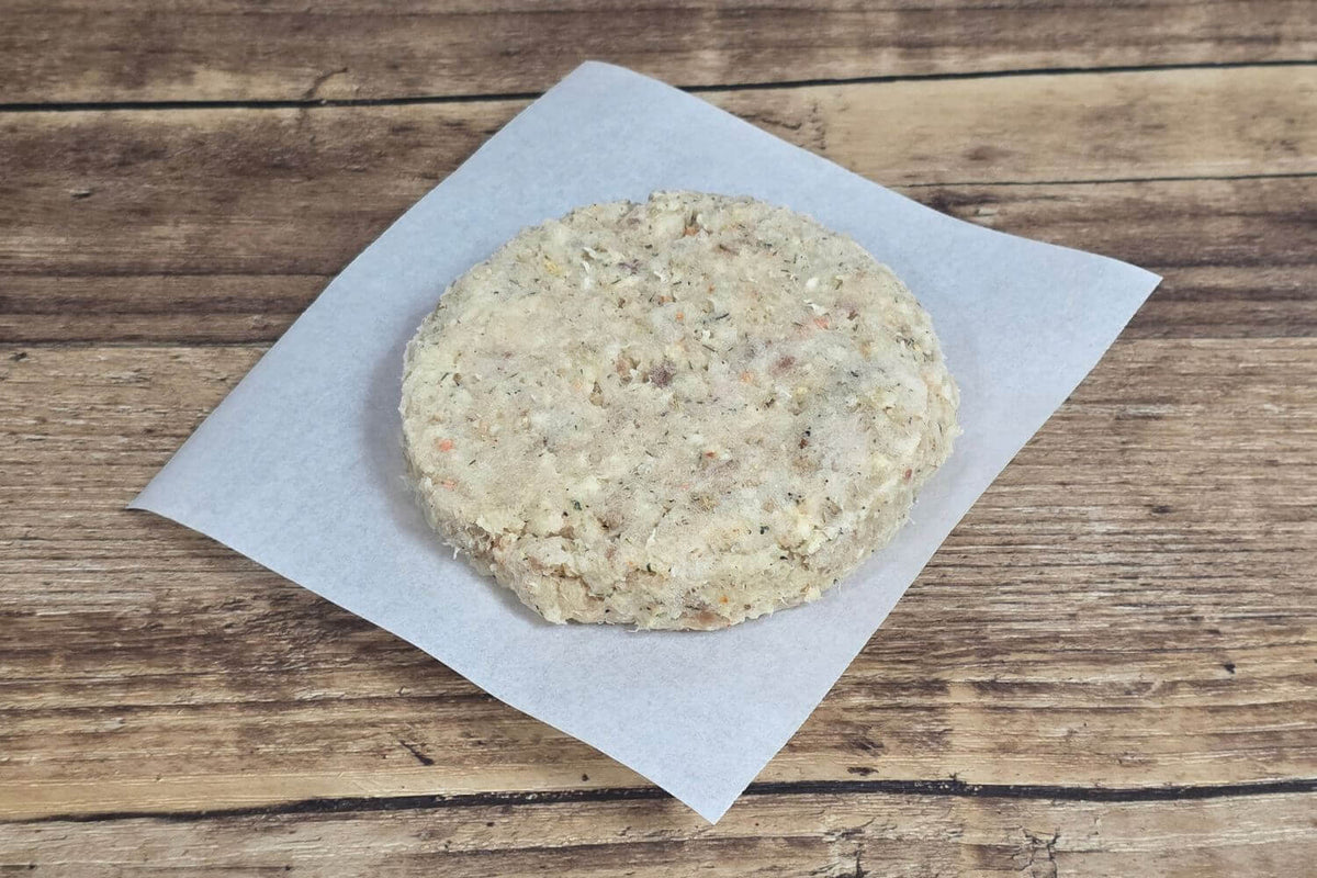 Uncooked Wild Alaska lingcod whitefish burger patty on parchment paper.