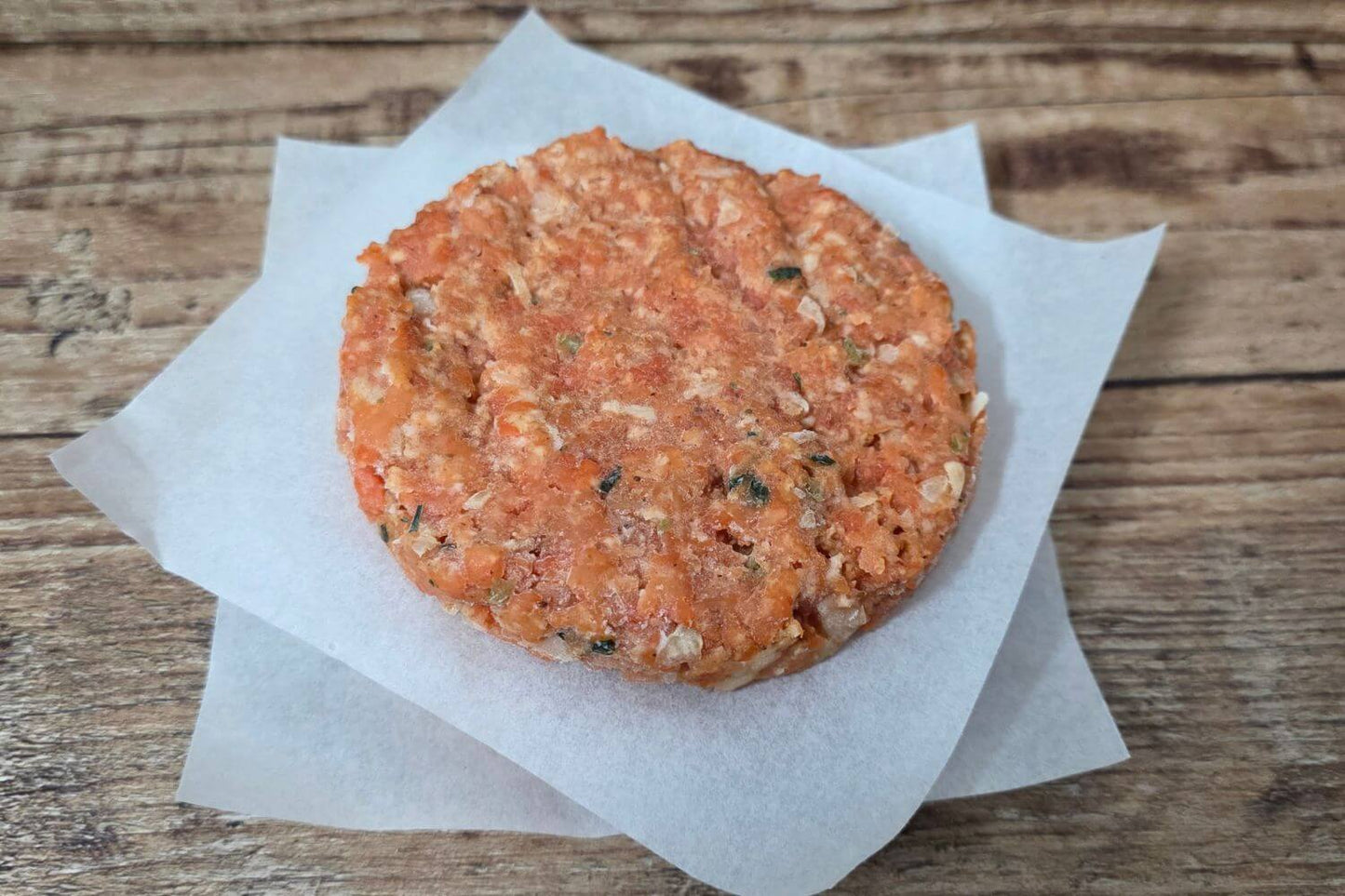 Wild Alaskan salmon burger patty on parchment paper