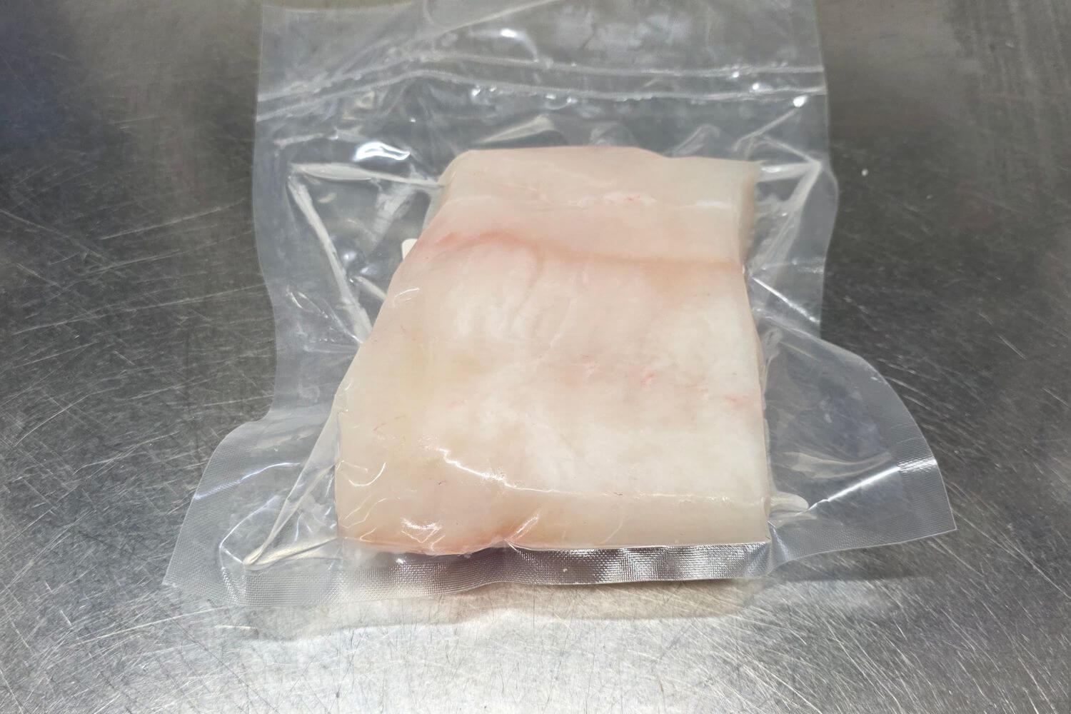 Individually vacuum-sealed wild Alaska white fish fillet prepared for freezing and storage.