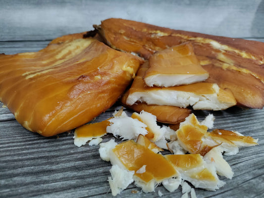 Smoked halibut fillets and flakes on a wooden surface