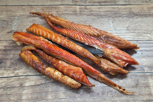 Smoked King Salmon Bellies on wooden background. Made from wild Alaskan king salmon, showing rich smoked flesh and natural marbling.