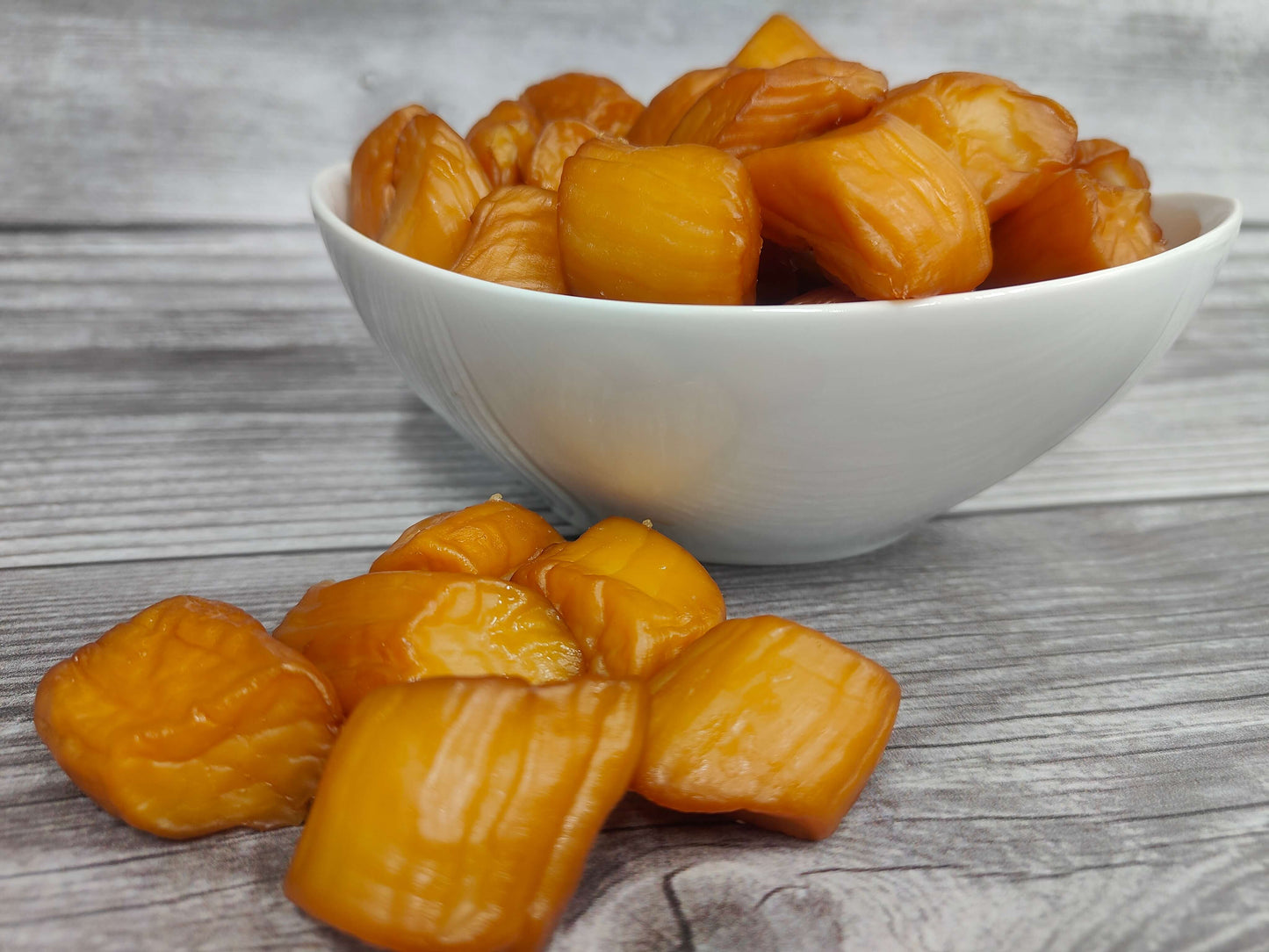 Bowl of smoked Weathervane scallops on a wooden surface