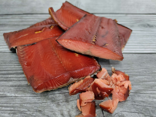 Smoked wild Alaskan sockeye salmon pieces on a wooden board.