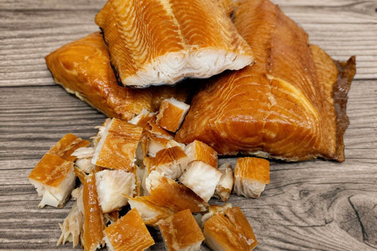 Smoked wild Alaskan black cod (sablefish) fillets and cubed pieces on a wooden board.