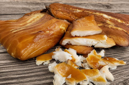 Smoked halibut fillets and flakes on a wooden surface