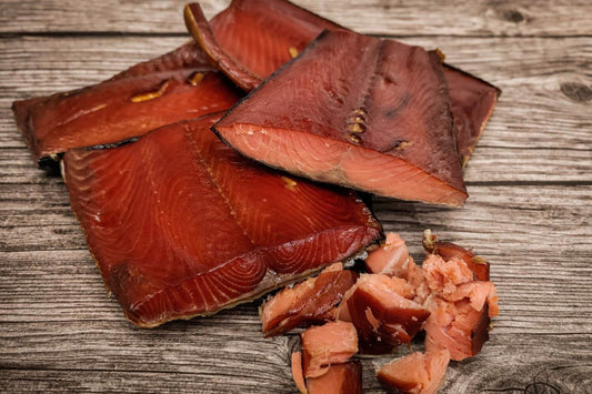 Smoked wild Alaskan sockeye salmon pieces on a wooden board.