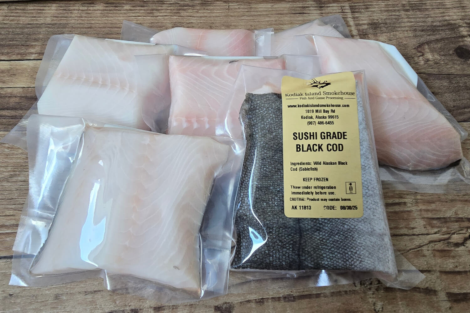Packaged sushi grade black cod on a wooden surface
