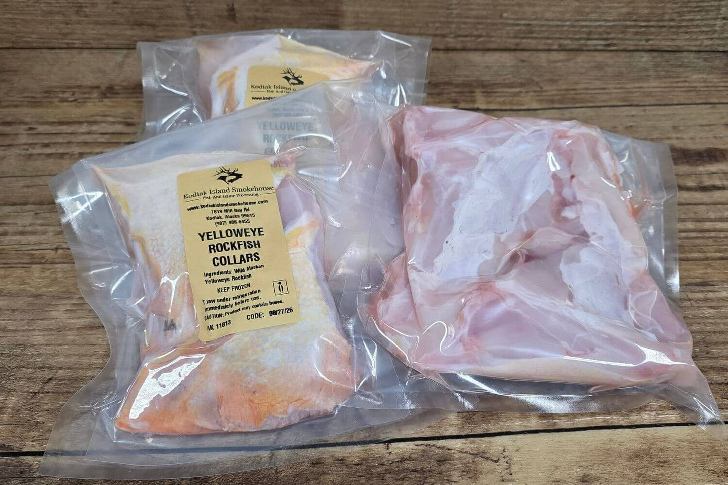 Vacuum-sealed packages of wild Alaska yelloweye collars from Kodiak Island Smokehouse displayed on a rustic wooden surface.
